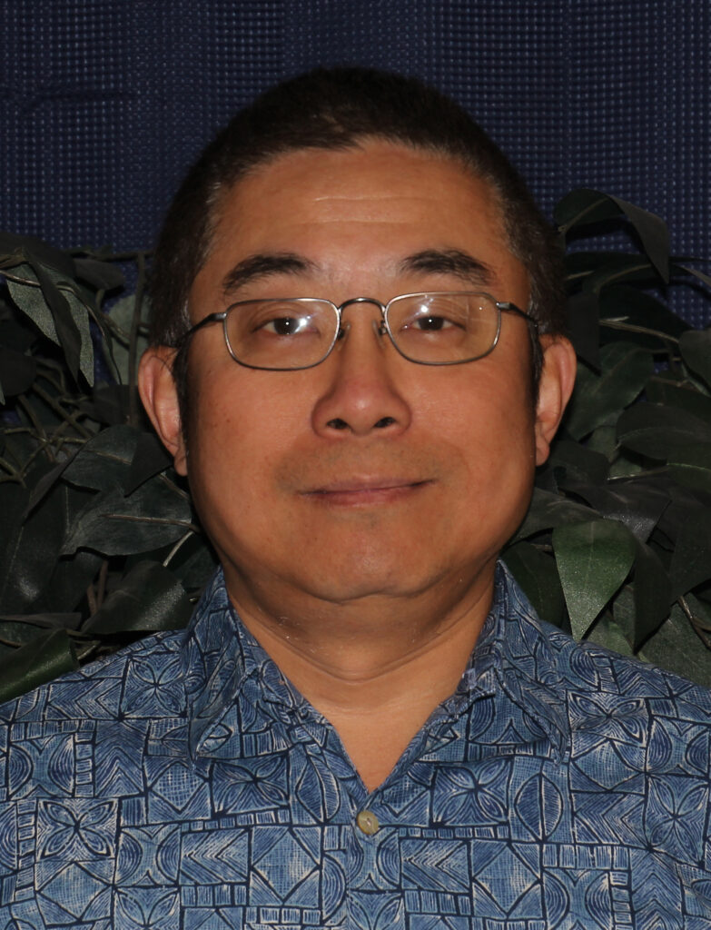 A portrait image of Gang Liu wearing a blue button-down