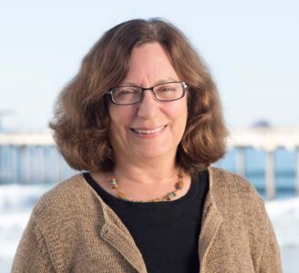 A headshot of Dr. Lynne Talley, posing in glasses and a beige cardigan.