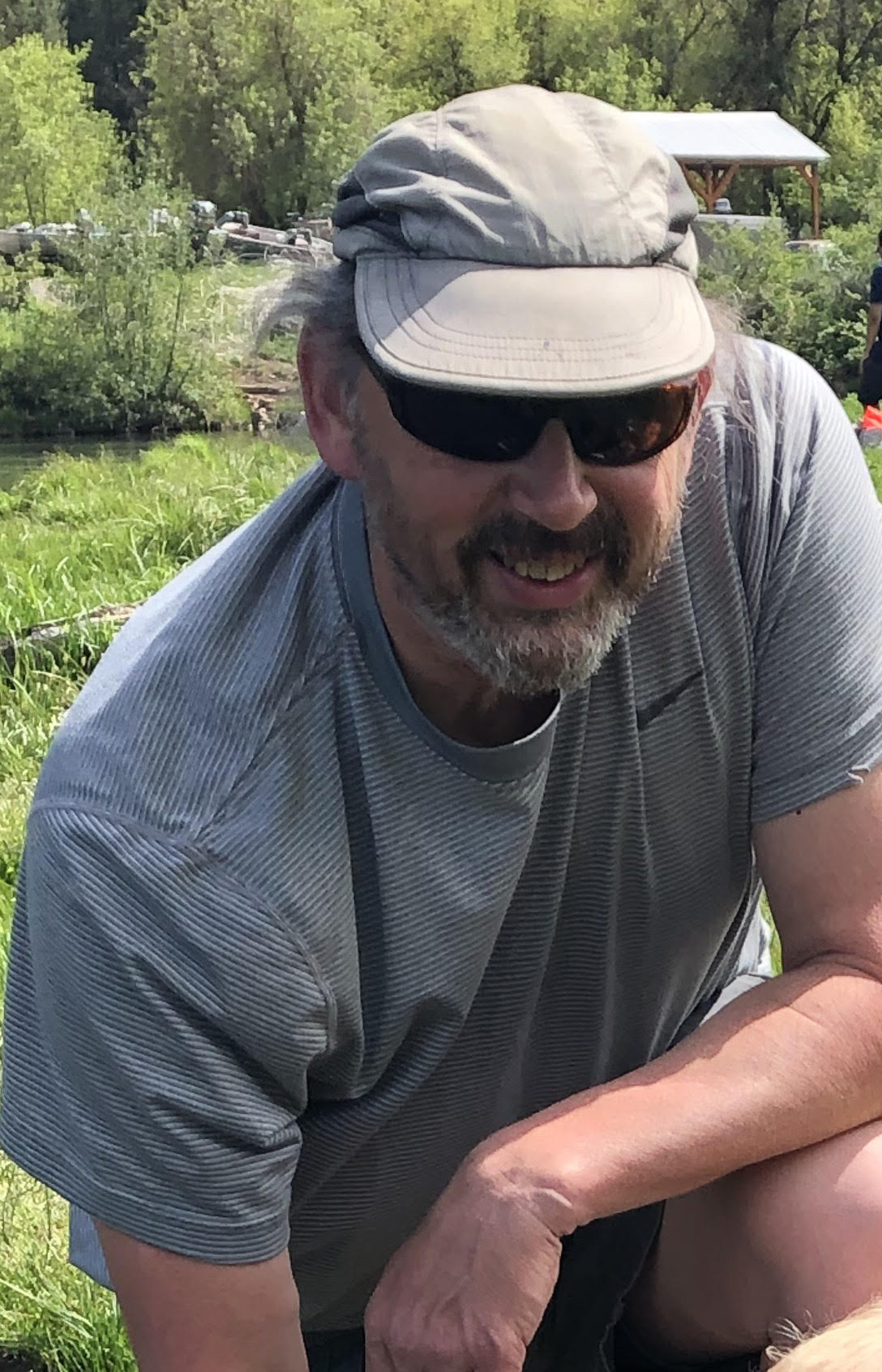 Dr. Jay Mace in the field, wearing a ball cap and sunglasses
