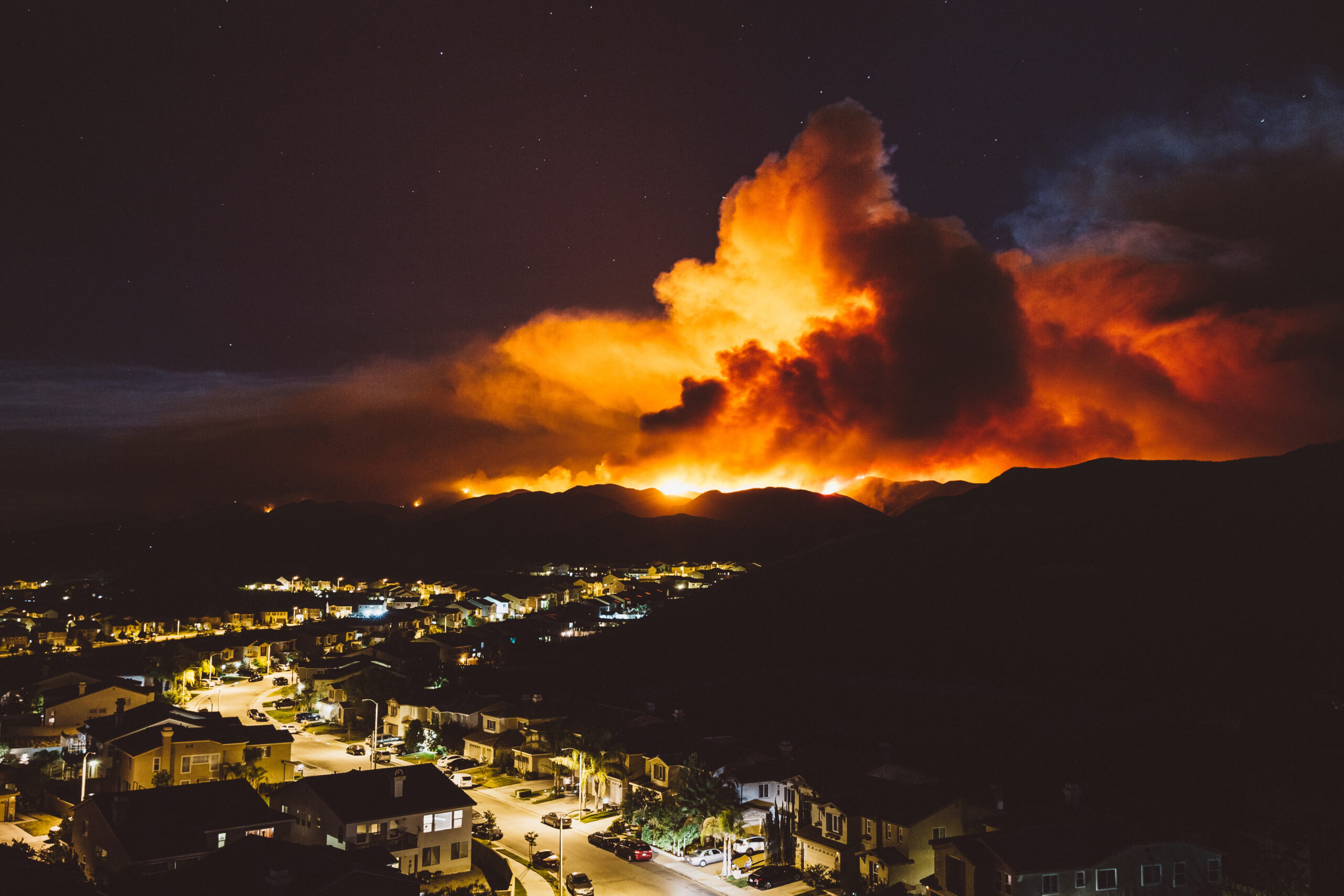 California wildfire burns near a residential area at night (Adobe Stock)